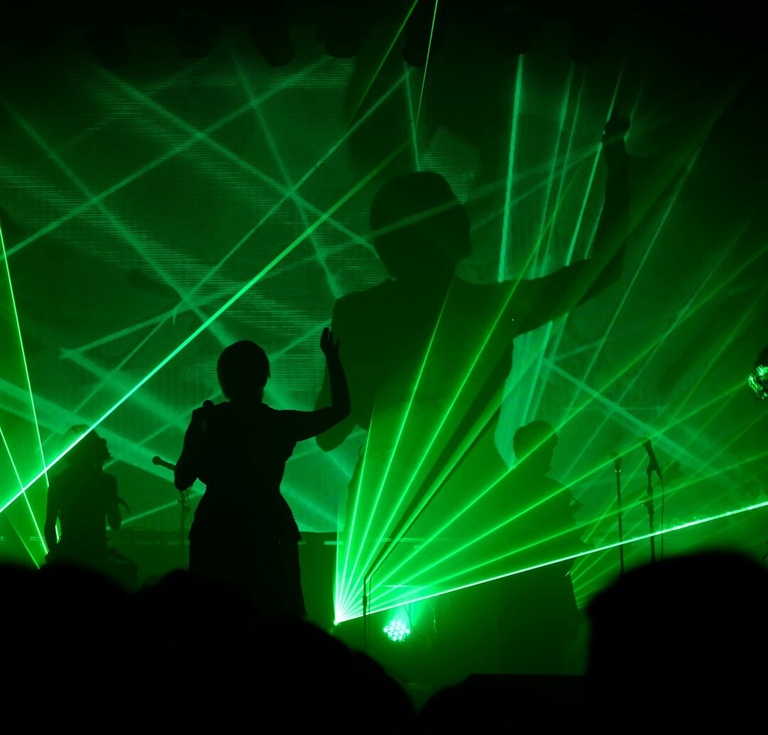 DJ performing at a nightclub event with colorful stage lights